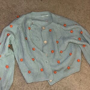 Women's light mint green cardigan with orange puffs